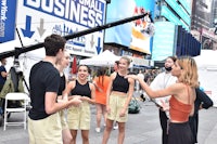 a group of dancers on a street in times square